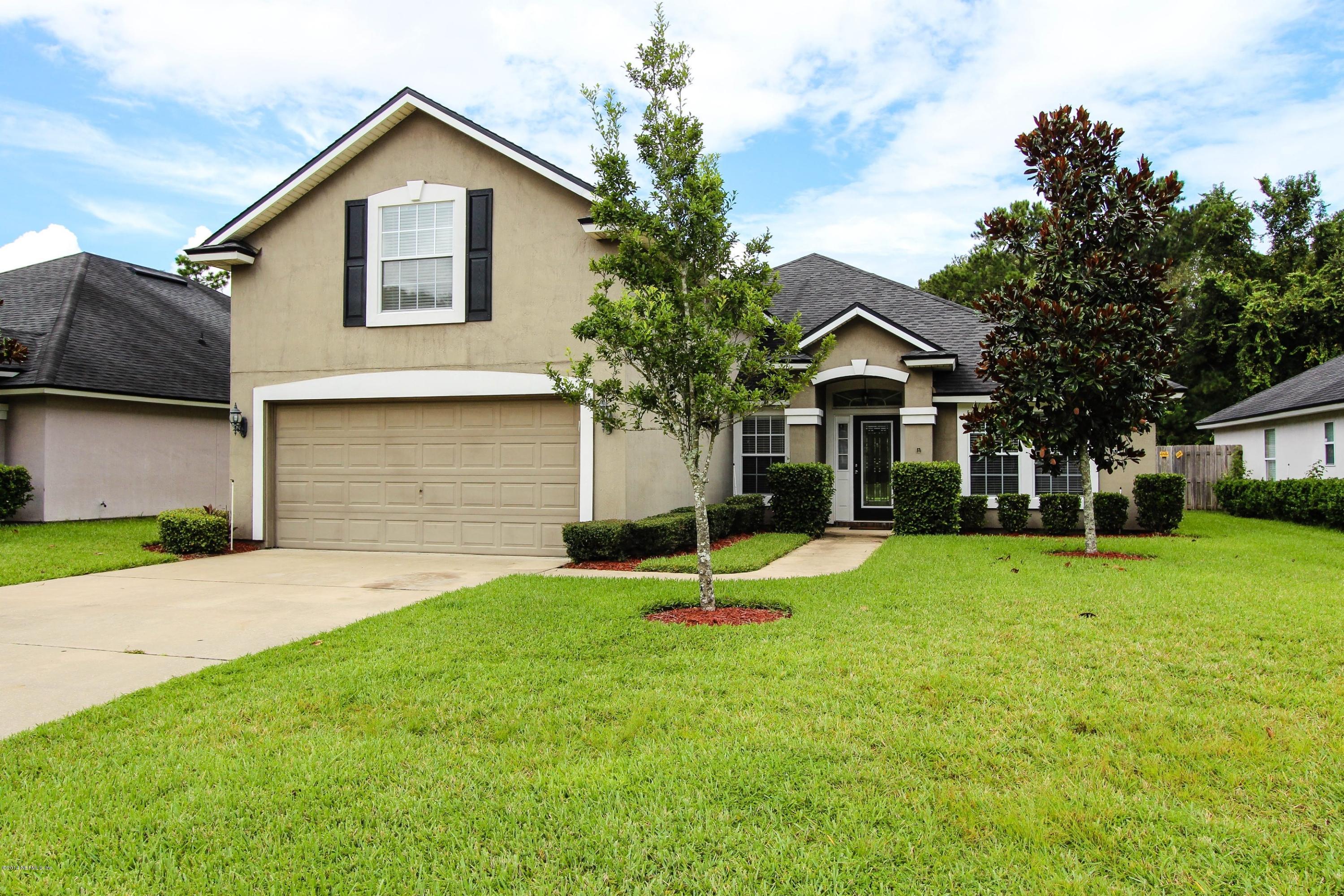 1252 Ribbon Road St. Johns, FL 32259 - Photo 1 of 27 a front view of a house with a yard and garage