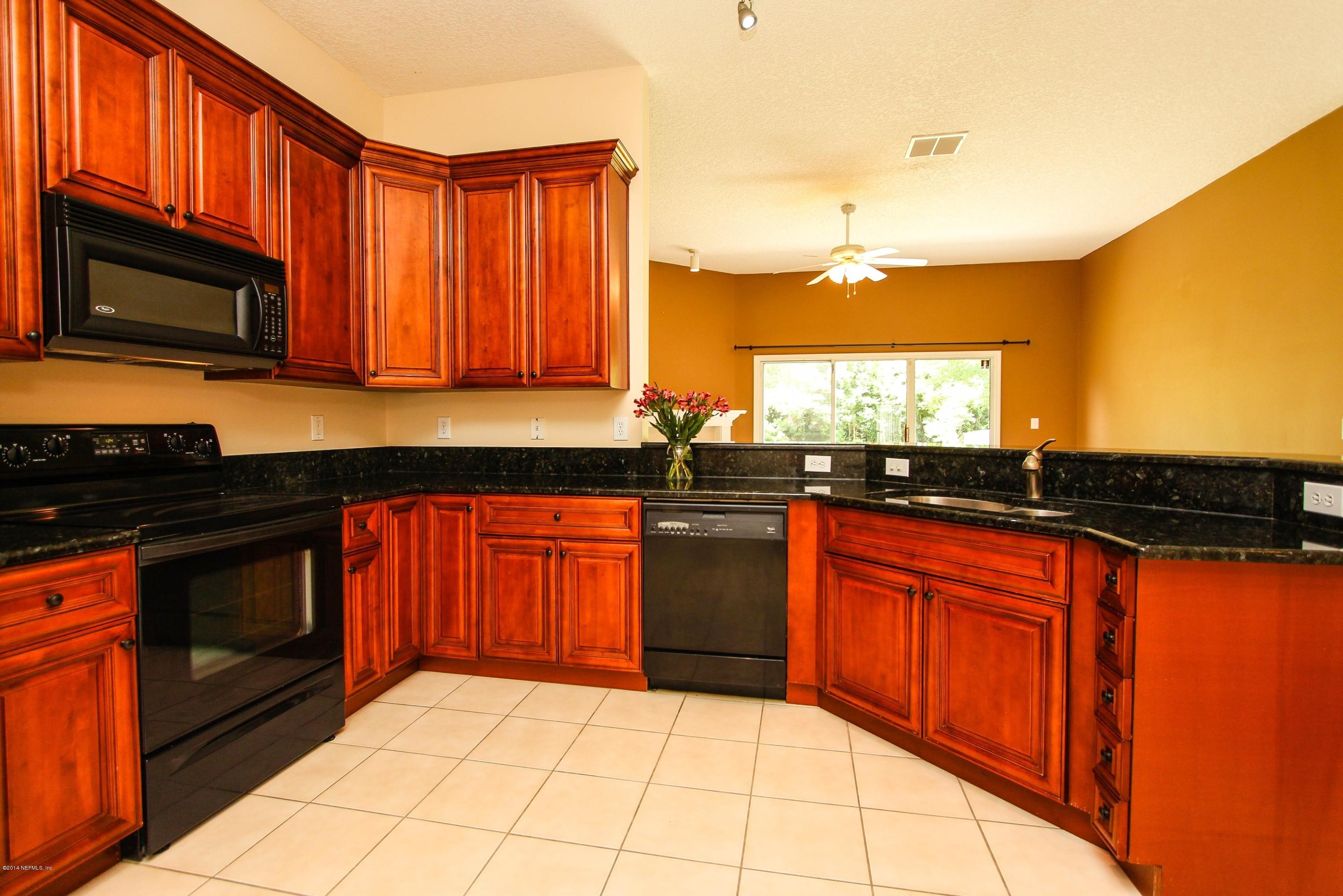 1252 Ribbon Road St. Johns, FL 32259 - Photo 12 of 27 a kitchen with stainless steel appliances granite countertop a stove a sink and a microwave