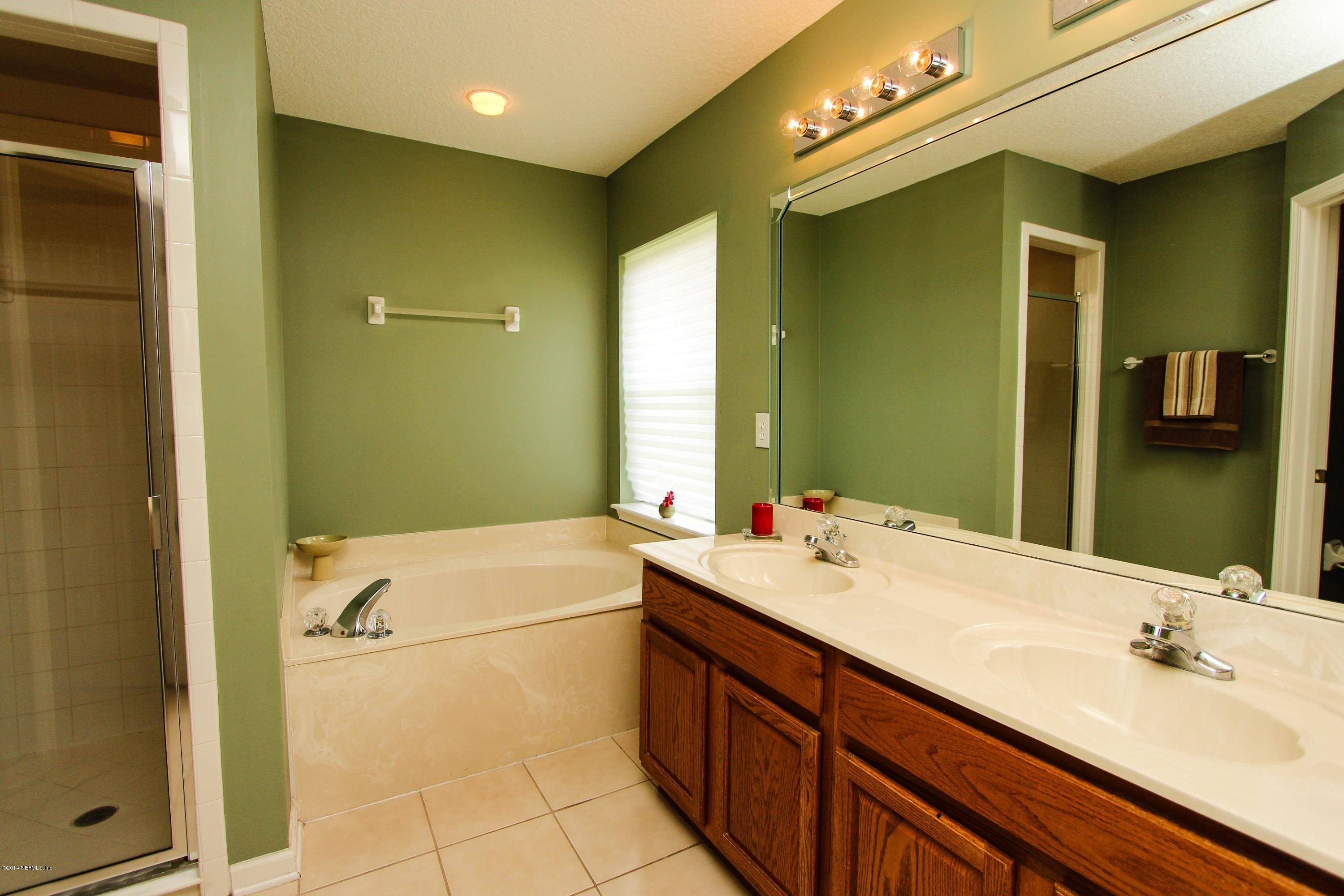 1252 Ribbon Road St. Johns, FL 32259 - Photo 17 of 27 a bathroom with a tub sink and mirror