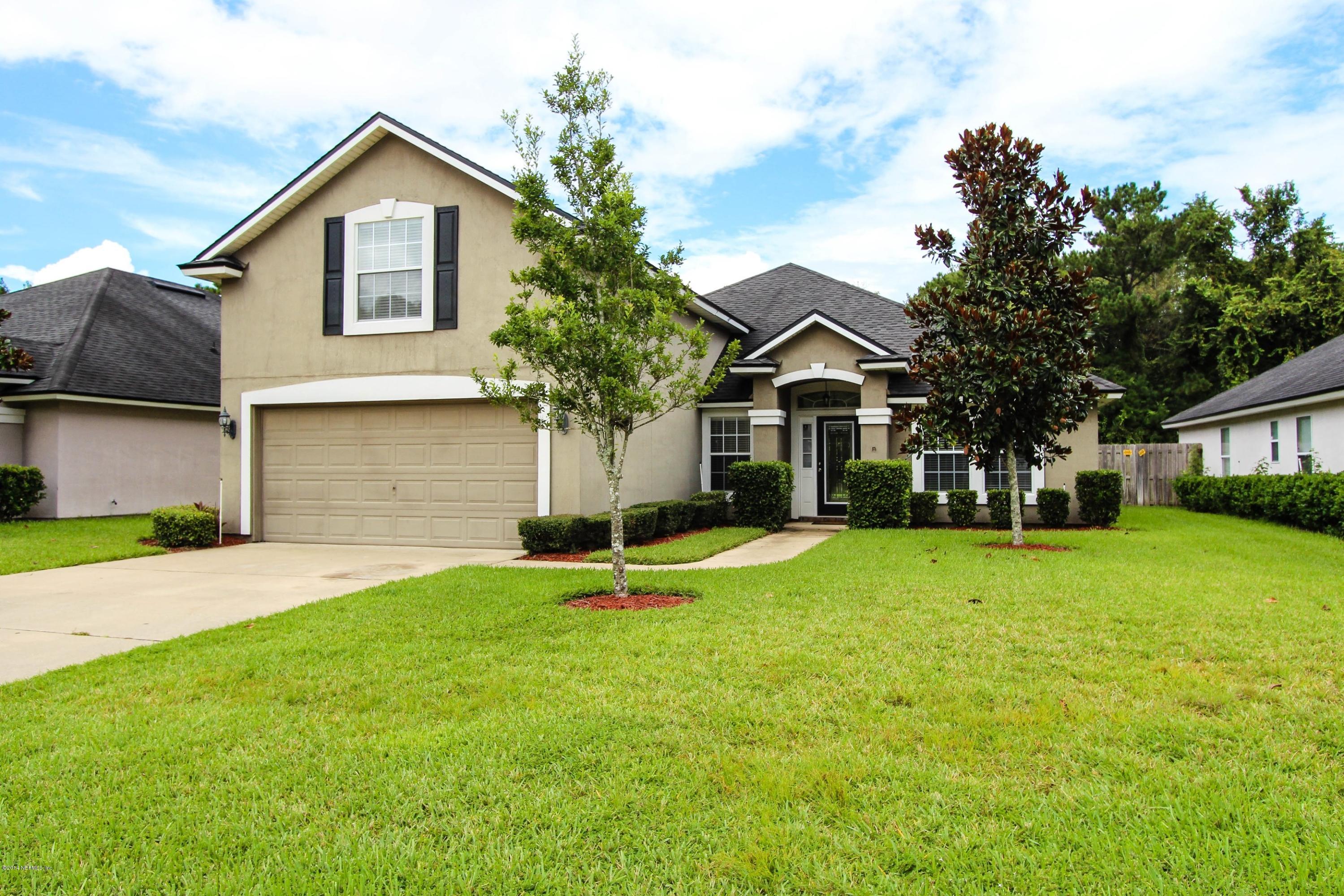 1252 Ribbon Road St. Johns, FL 32259 - Photo 2 of 27 a front view of a house with a yard and garage