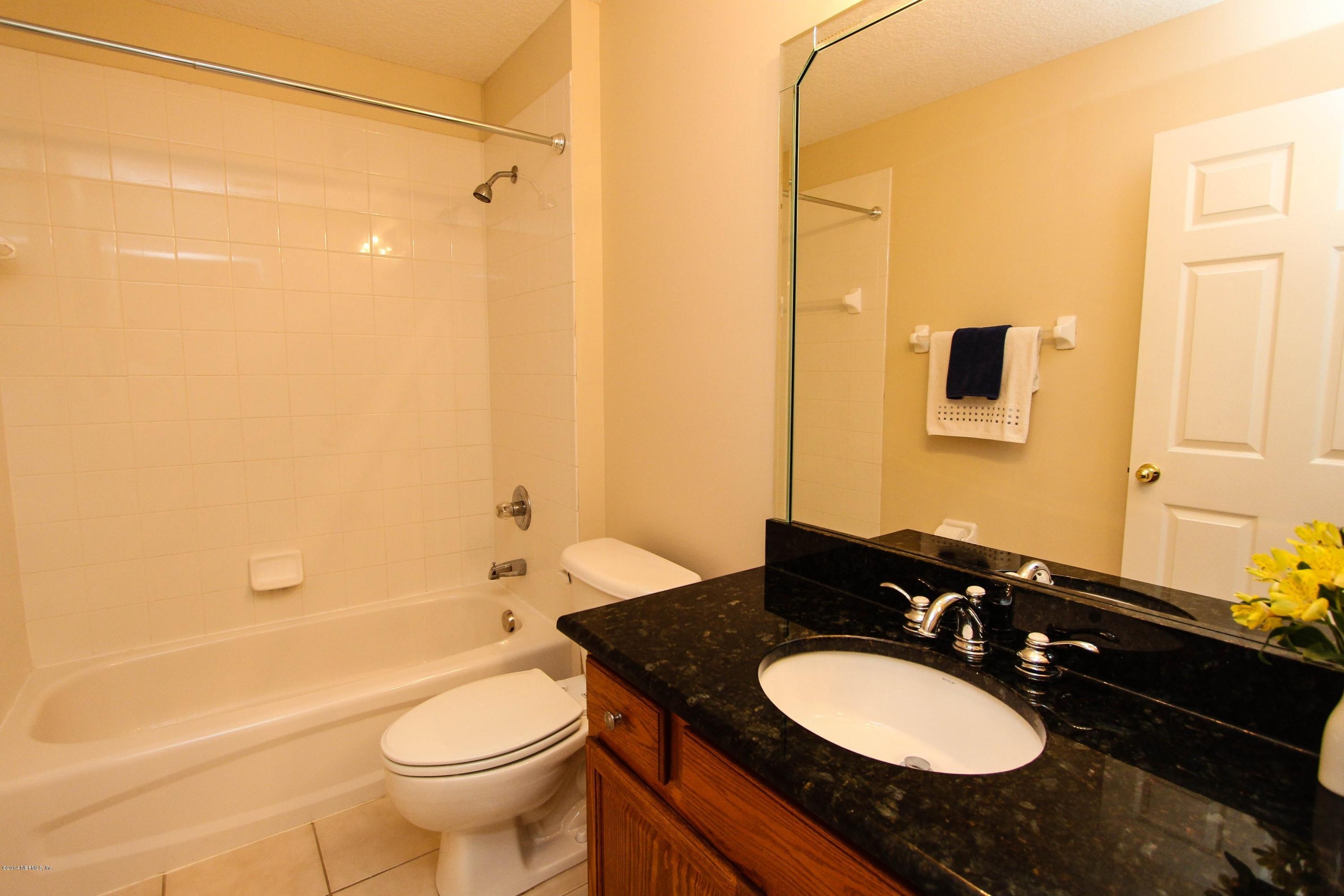 1252 Ribbon Road St. Johns, FL 32259 - Photo 21 of 27 a bathroom with a granite countertop sink toilet a mirror and shower