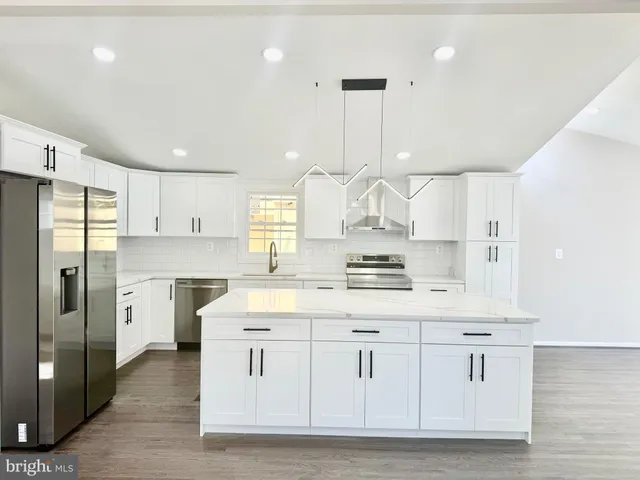 a large kitchen with cabinets and stainless steel appliances
