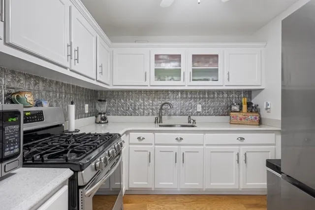 a kitchen with white cabinets and appliances
