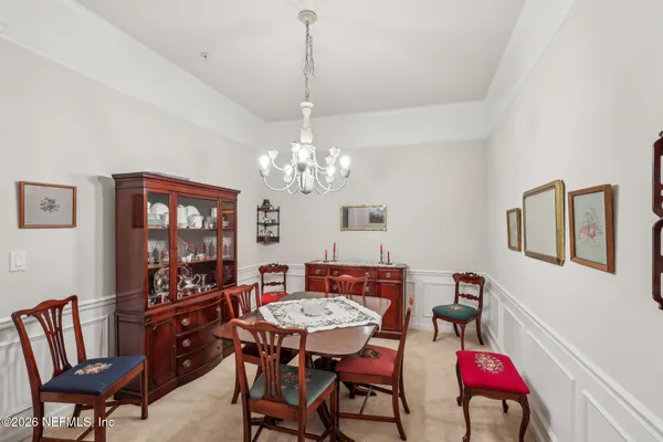 a view of a dining room with furniture and a chandelier