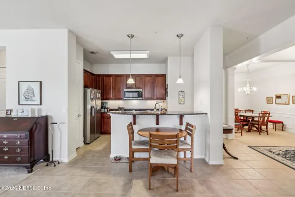 a kitchen with stainless steel appliances kitchen island granite countertop a refrigerator and a stove top oven