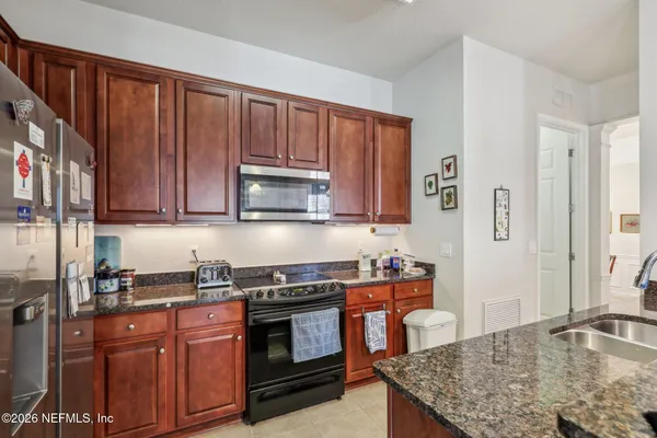 a kitchen with stainless steel appliances granite countertop wooden cabinets and a stove top oven