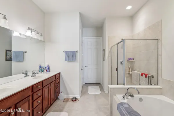 a bathroom with a tub sink and mirror