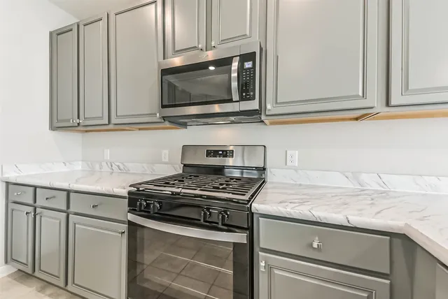 a view of kitchen with kitchen island and stainless steel appliances