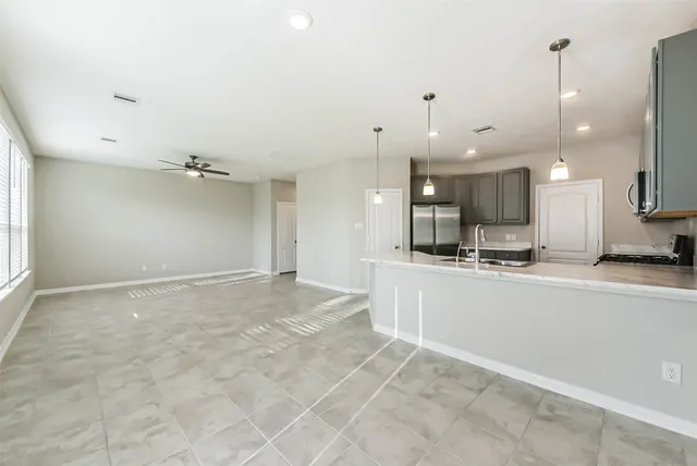 a view of a kitchen with kitchen island a sink stainless steel appliances and cabinets