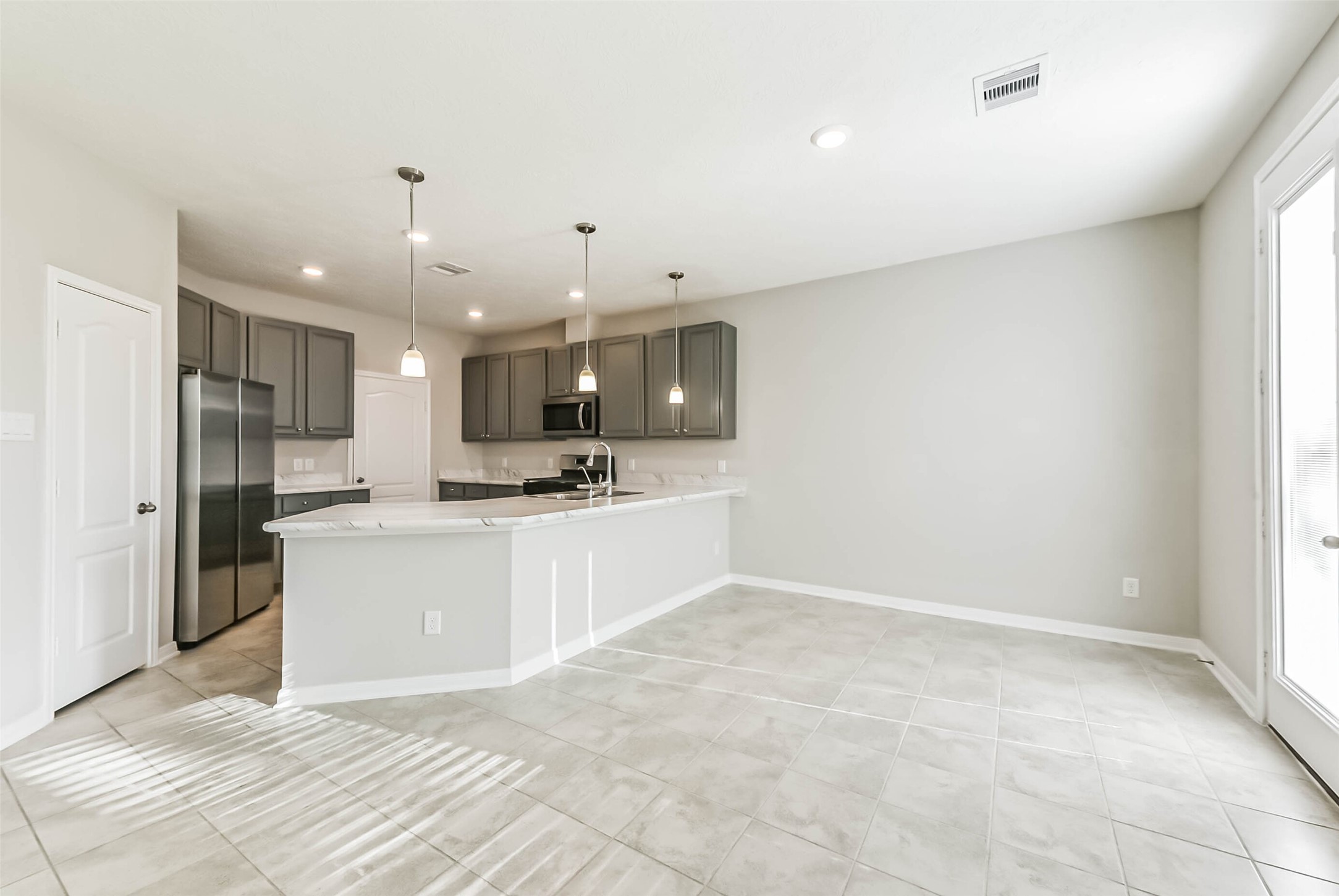 11626 Moonstruck Lane Houston, TX 77048 - Photo 15 of 35 a view of a kitchen with kitchen island a sink stainless steel appliances and cabinets