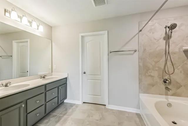 a bathroom with a double vanity sink mirror and shower
