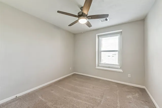 an empty room with closet and a chandelier fan