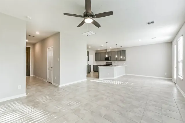 an empty room with fan and windows