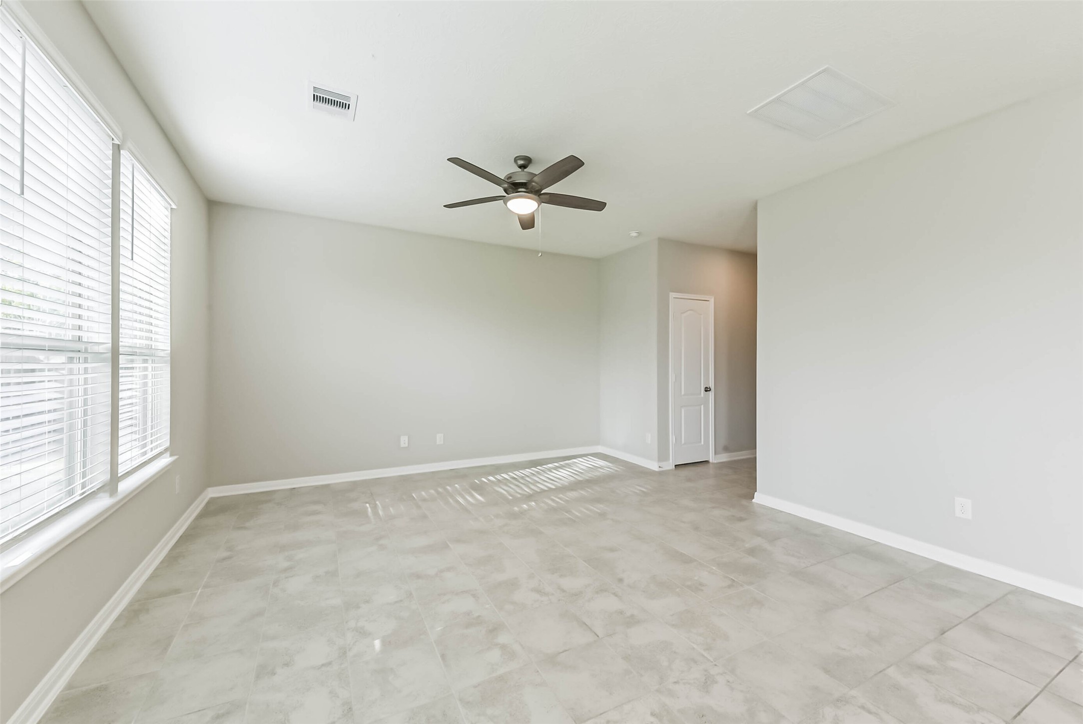 11626 Moonstruck Lane Houston, TX 77048 - Photo 7 of 35 an empty room with fan and windows