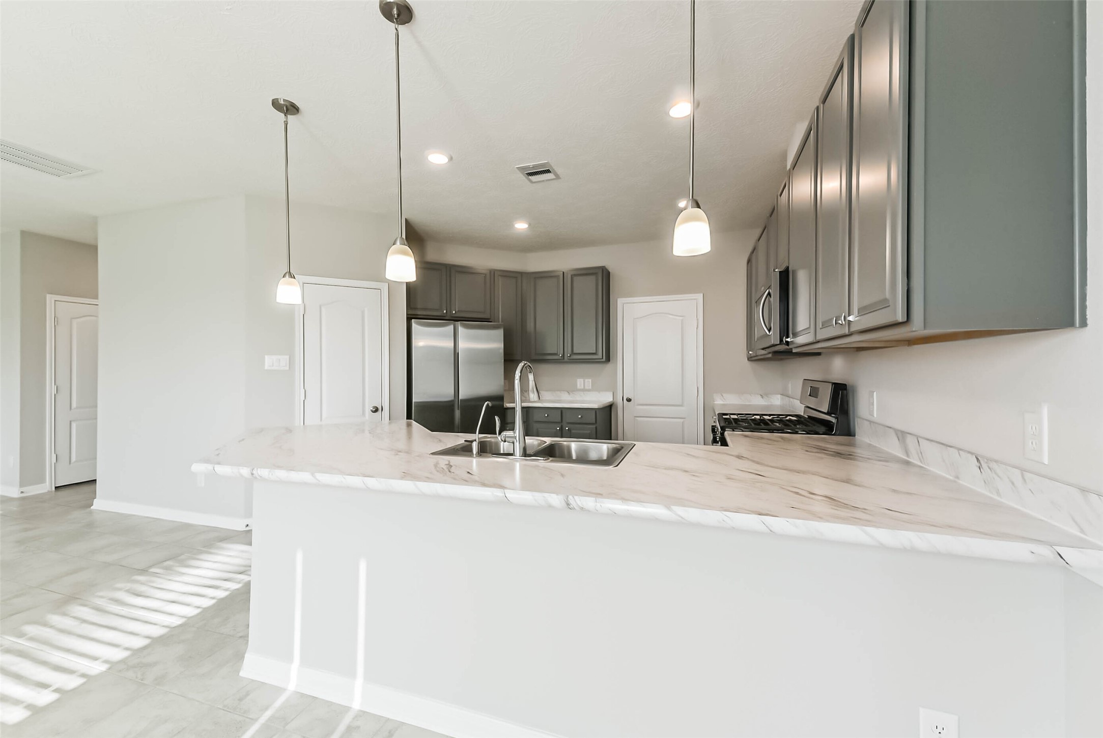 11626 Moonstruck Lane Houston, TX 77048 - Photo 9 of 35 a large kitchen with kitchen island a sink stainless steel appliances and cabinets