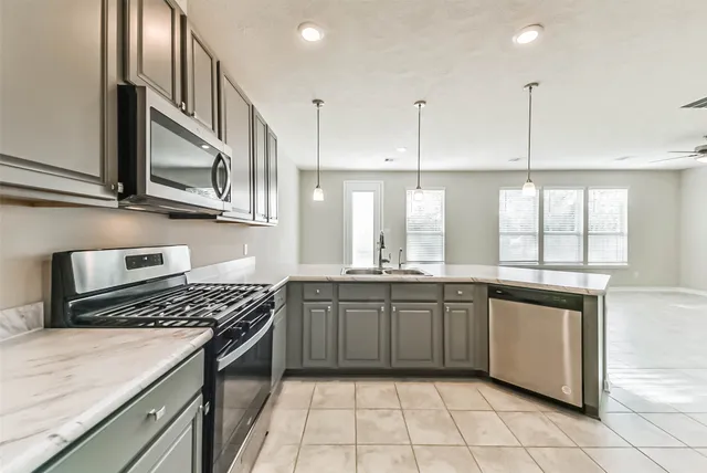 a kitchen with stainless steel appliances granite countertop a sink and a refrigerator