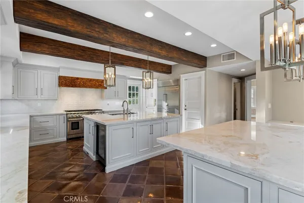 a kitchen with stainless steel appliances granite countertop a stove a sink and a white cabinets