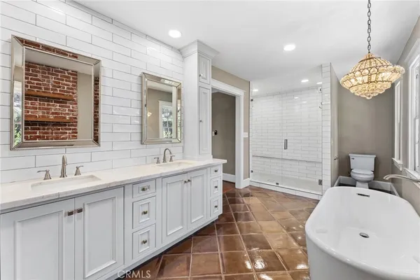 a spacious bathroom with a double vanity sink a mirror and a bathtub