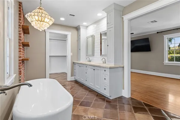 an empty room with wooden floor and ceiling fan