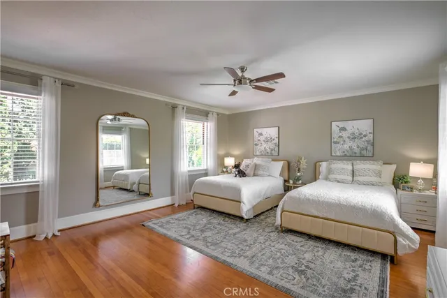 a spacious bedroom with two beds and painting on the wall