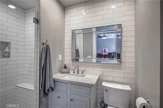 a bathroom with a granite countertop sink vanity and mirror