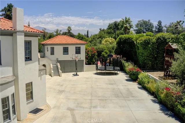 a view of a white house with a yard and potted plants