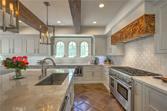 a kitchen with granite countertop a sink stainless steel appliances and cabinets