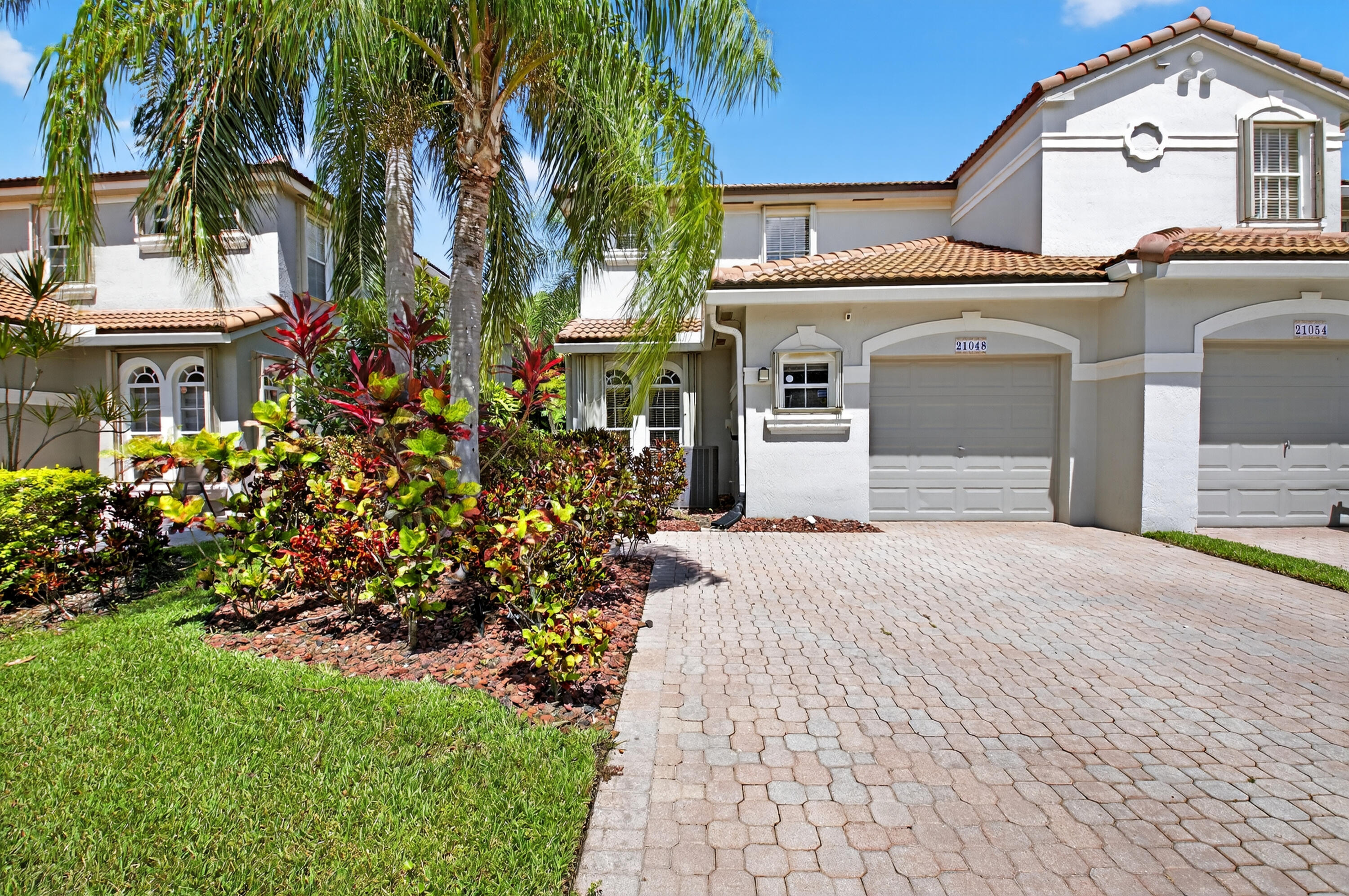 21048 Vía Eden Boca Raton, FL 33433 - Photo 1 of 53 a front view of a house with a garden