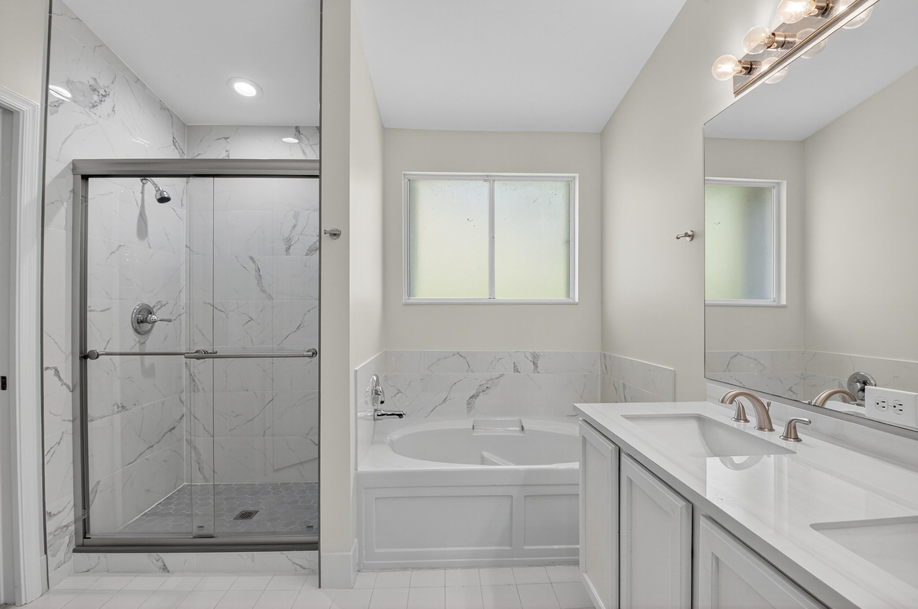 21048 Vía Eden Boca Raton, FL 33433 - Photo 18 of 53 a bathroom with a tub sink shower and mirror