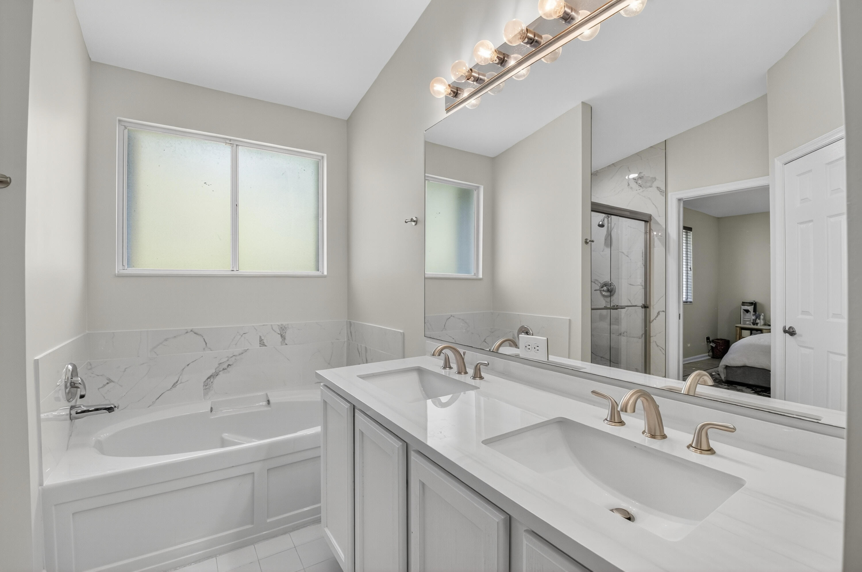 21048 Vía Eden Boca Raton, FL 33433 - Photo 19 of 53 a bathroom with a sink a large mirror and a bathtub