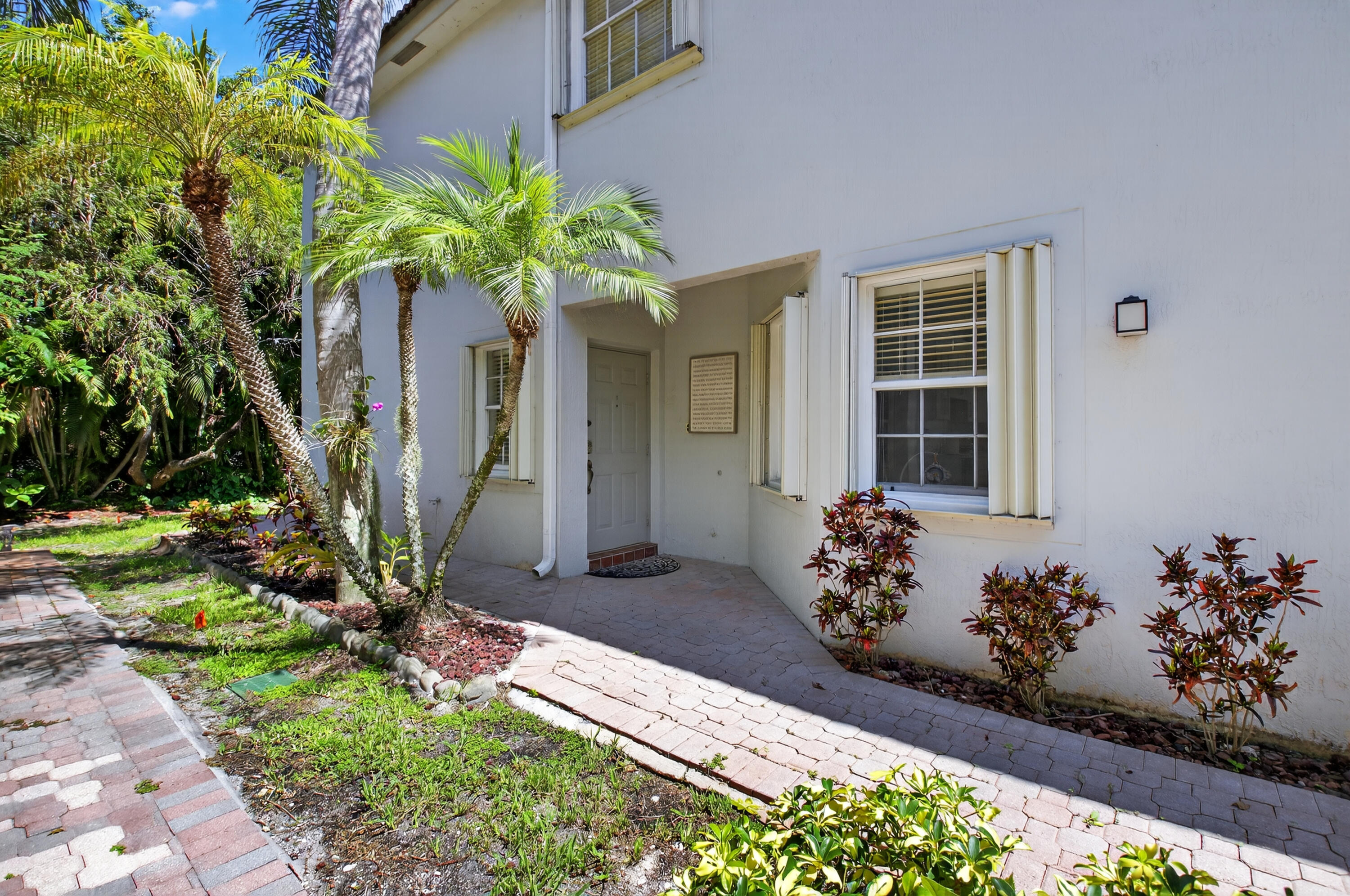 21048 Vía Eden Boca Raton, FL 33433 - Photo 10 of 53 a front view of a house with a lot of flowers