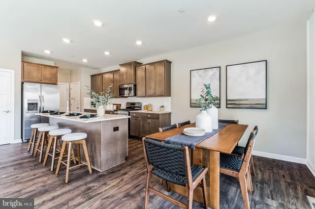 a kitchen with stainless steel appliances granite countertop a dining table chairs and granite counter tops