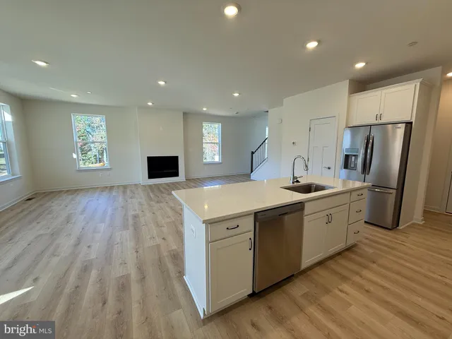 a large kitchen with stainless steel appliances granite countertop a lot of cabinets and wooden floor