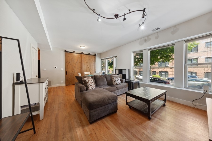 3942 North Clarendon Avenue, Unit 1N Chicago, IL 60613 - Photo 2 of 13 a living room with furniture and a large window
