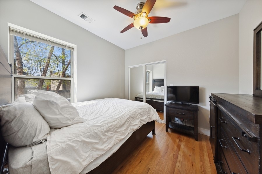 3942 North Clarendon Avenue, Unit 1N Chicago, IL 60613 - Photo 9 of 13 a bedroom with a bed and a flat screen tv