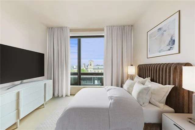 a bedroom with bed and a flat screen tv