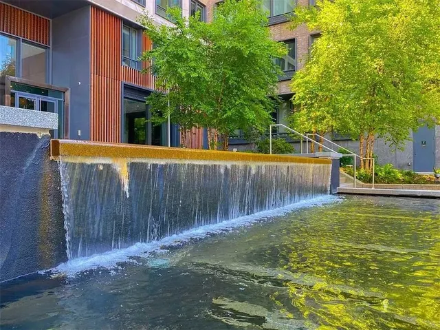 a view of a backyard with large trees and wooden fence