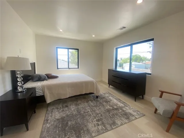 a spacious bedroom with a bed and wooden floor