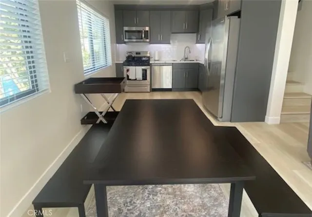 a kitchen with a table chairs refrigerator and stove