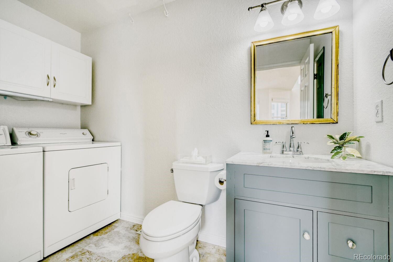 5174 Buckingham Road Boulder, CO 80301 - Photo 16 of 33 a bathroom with a toilet sink vanity and mirror