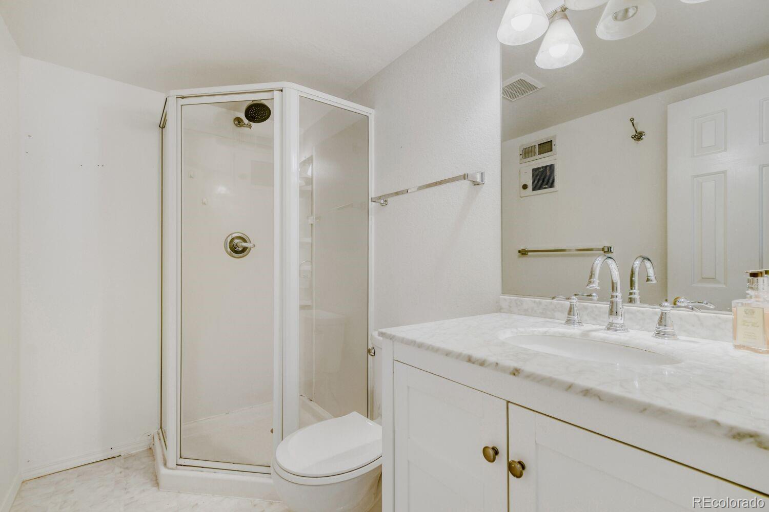 5174 Buckingham Road Boulder, CO 80301 - Photo 28 of 33 a bathroom with a granite countertop sink a toilet and shower