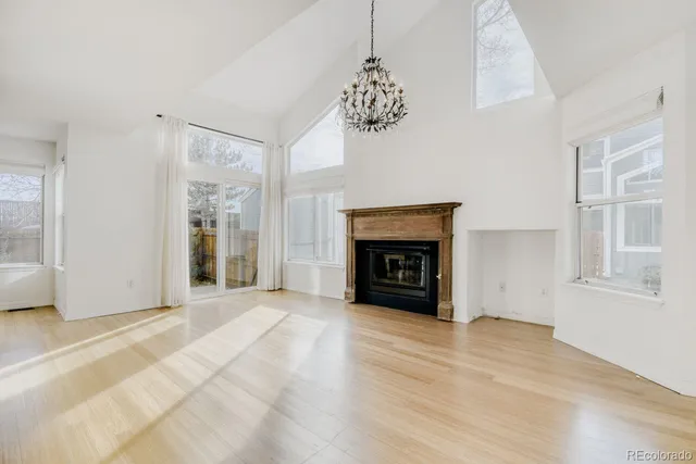 a kitchen with stainless steel appliances granite countertop a refrigerator a stove top oven a sink and white cabinets with wooden floor