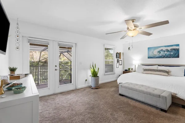 a bedroom with a balcony a bed and a chandelier