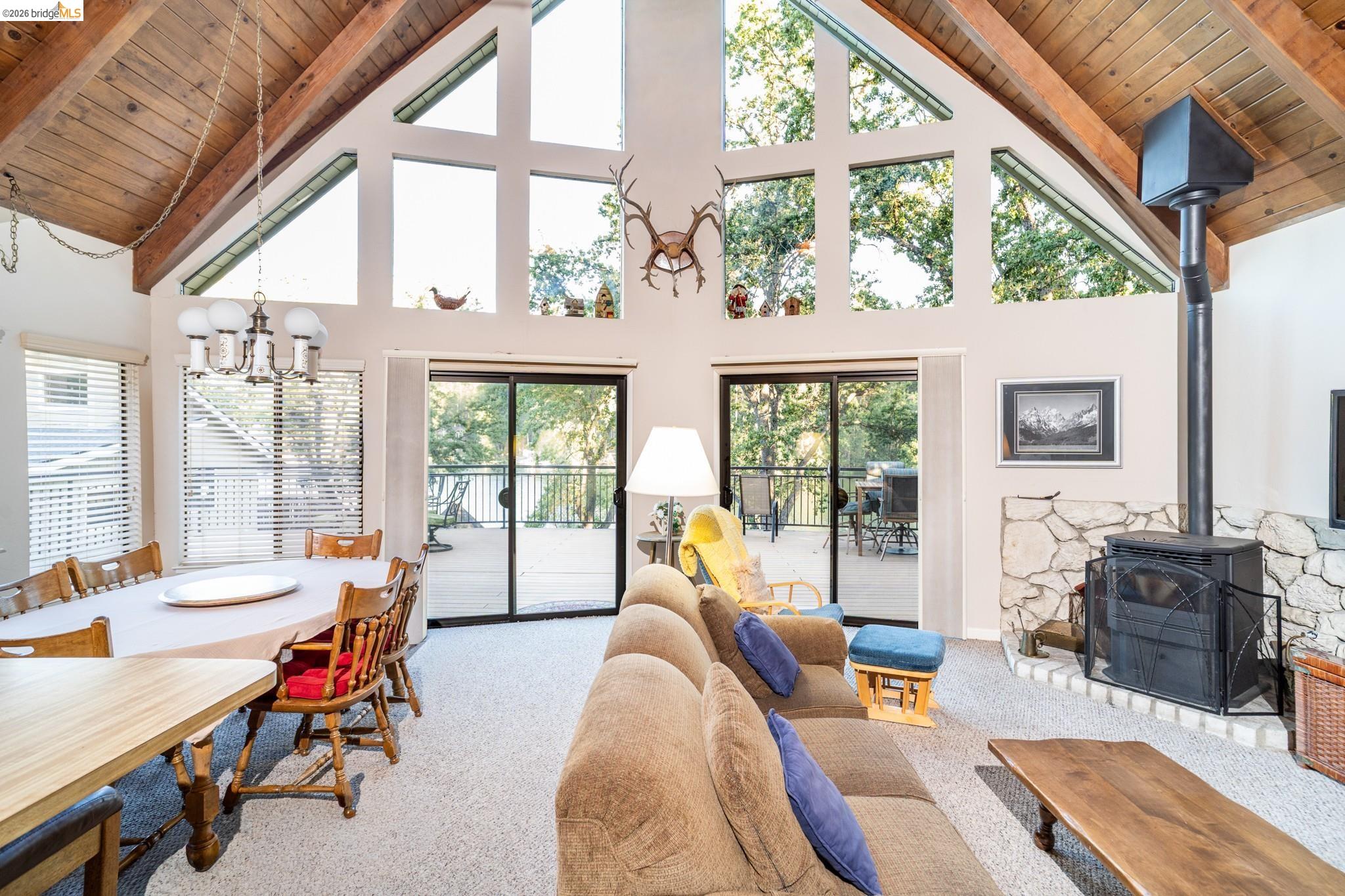 19711 Pleasantview Drive Groveland, CA 95321 - Photo 14 of 39 Vaulted ceilings with exposed timber beams and a floor-to-ceiling window wall define this living space