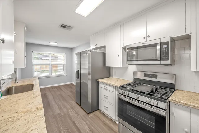 a kitchen with a stove a sink and a refrigerator