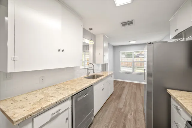 a kitchen with granite countertop a sink stove and cabinets