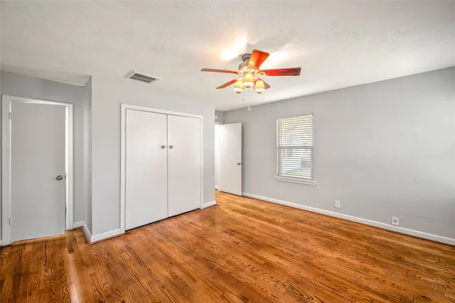 a view of a room with wooden floor and ceiling fan