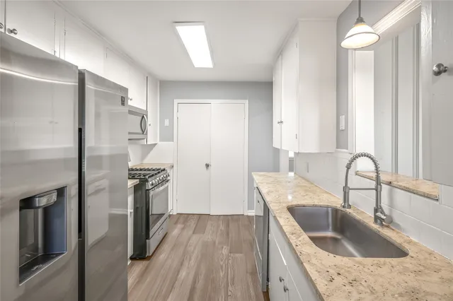 a kitchen with stainless steel appliances granite countertop a refrigerator sink and stove