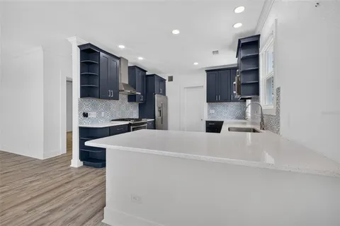 a large white kitchen with stainless steel appliances and cabinets