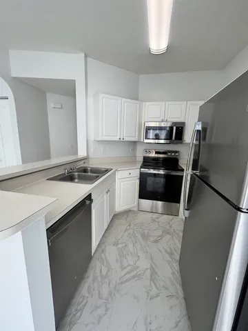 a kitchen with granite countertop cabinets and refrigerator